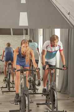 年轻的活跃的人健身房骑自行车