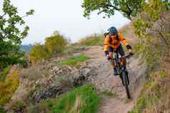骑自行车的人橙色骑山自行车秋天岩石小道极端的体育运动复古骑自行车概念
