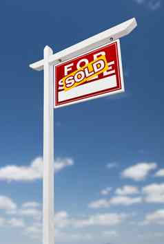 面对出售出售真正的房地产标志蓝色的天空