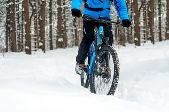骑自行车的人蓝色的骑山自行车美丽的冬天森林极端的体育运动复古骑自行车概念