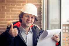 建设工人给竖起大拇指前面新构造住宅建筑软焦点健美的