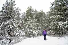女人徒步旅行大背包美丽的冬天森林