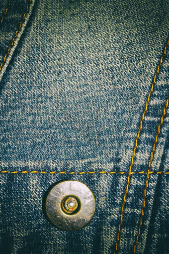 蓝色的牛仔裤纹理背景按钮缝