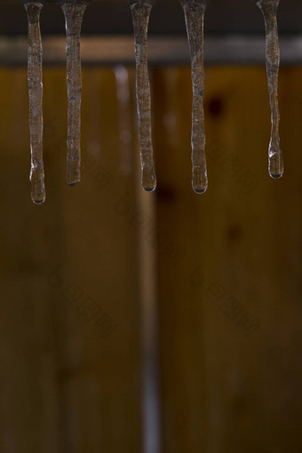 冰柱挂木木板背景温暖的冬天一天转移春天浅深度场