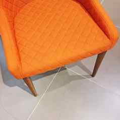 明亮的橙色扶手椅瓷砖地板上