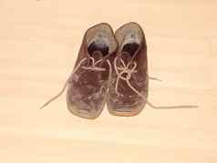 关闭棕色（的）脏泥泞的走鞋子木地板上