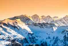 冬天雪山峰阿尔卑斯山脉山全景照亮日落晚上时间奥地利瑞士欧洲