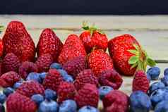 健康的混合水果成分草莓树莓蓝莓浆果乡村白色木背景免费的空间文本复制空间横幅