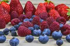 健康的混合水果成分草莓树莓蓝莓浆果乡村白色木背景特写镜头宏图像