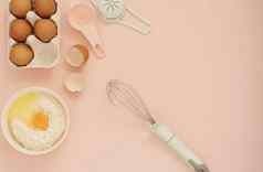 成分厨房烤工具烹饪蛋糕糖果鸡蛋面粉搅拌柔和的头昏眼花的粉红色的背景前视图假期烘焙生活