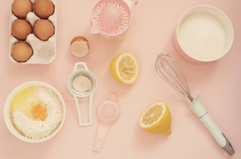 成分厨房烤工具烹饪柠檬蛋糕糖果鸡蛋面粉手榨汁机糖柔和的头昏眼花的粉红色的背景前视图假期烘焙生活