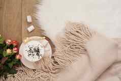 舒适的冬天早晨卡布奇诺咖啡花束玫瑰温暖的围巾白色皮毛地毯地板上