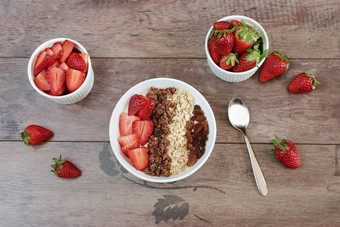 健康的早餐酸奶燕麦片葡萄干草莓牛奶什锦早餐水果早餐木背景