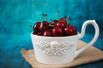 新鲜的樱桃白色碗大杯新鲜的水果水果沙拉蓝色的背景乡村风格