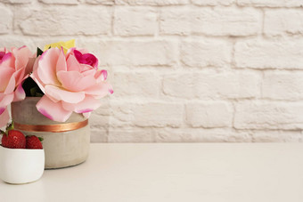 粉红色的玫瑰模拟风格<strong>摄影</strong>砖墙产品显示草莓白色桌子上<strong>花瓶</strong>粉红色的玫瑰时尚生活方式