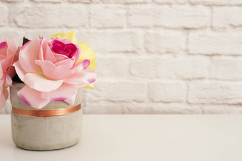 粉红色的玫瑰模拟风格摄影砖墙产品显示白色桌子上花瓶粉红色的玫瑰时尚生活方式
