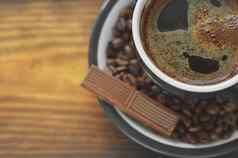 棕色（的）咖啡杯泡沫飞碟咖啡豆子一块巧克力