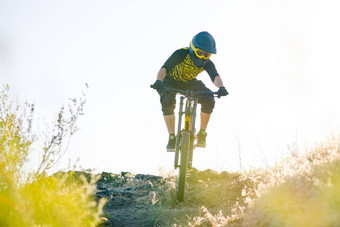 骑自行车的人骑山自行车夏天岩石小道晚上极端的体育运动复古骑自行车概念
