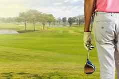 高尔夫球球员持有高尔夫球俱乐部高尔夫球
