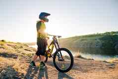 骑自行车的人准备骑山自行车夏天岩石小道晚上极端的体育运动骑自行车