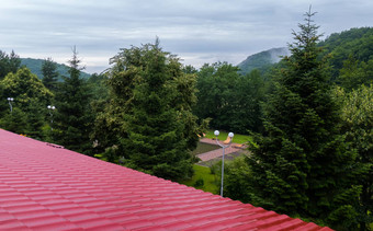 红色的屋顶小屋背景高松柏科的树绿色山范围