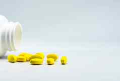 黄色的椭圆形平板电脑药片打开白色瓶白色背景美丽的有创意的模式复制空间文本温和的温和的疼痛管理疼痛杀手医学制药行业药店背景全球医疗保健概念非甾体抗炎药药物