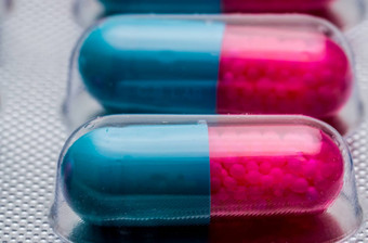 宏拍摄细节蓝色的粉红色的胶囊颗粒一边药片药片泡包制药剂量形式包装伊曲康唑抗真菌医学制药行业药店背景