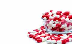 红色的白色抗生素胶囊药片玻璃碗白色背景复制空间药物电阻概念抗生素药物合理的全球医疗保健概念