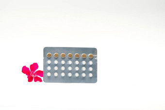 避孕药片粉红色的花白色背景出生控制药片家庭规划概念