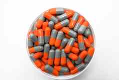 前视图灰色橙色胶囊药片塑料容器白色背景抗生素药物电阻制药行业药店背景全球医疗保健概念
