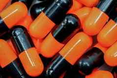 前视图橙色黑色的胶囊药片抗生素药物电阻制药行业药店背景全球医疗保健概念