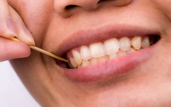 亚洲女人清洁牙齿食物卡住了牙齿竹子木牙签早餐午餐晚餐个人牙科护理亚洲风格牙科健康坏呼吸问题概念