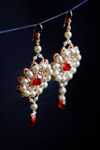 手工制作的珠宝使珠子宏耳环白色珠子耳环石头美丽的饰品耳环红色的珠子饰品黑色的背景