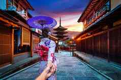 女人穿日本传统的和服持有男人的手领先的yasaka宝塔真相扎卡街《京都议定书》日本