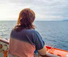 快乐女人海岸线海享受巡航船旅程视图回来