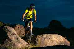 骑自行车的人骑山自行车岩石小道晚上极端的体育运动复古骑自行车概念