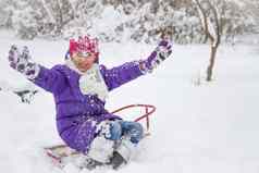 孩子女孩公园雪橇玩雪