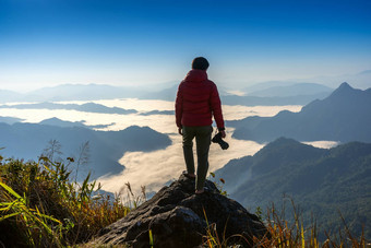 摄影师手持有相机站前岩石自然旅行概念