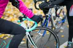 年轻的女骑自行车的人路自行车休息公园冷秋天一天健康的生活方式