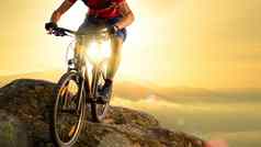 骑自行车的人红色的骑自行车岩石日出极端的体育运动复古骑自行车概念