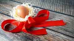 鸡蛋巢稻草红色的缎丝带木表格