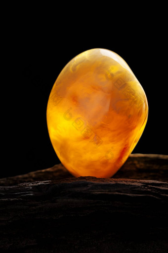 自然琥珀色的一块黄色的不透明的自然琥珀色的大一块黑暗用石头砸木