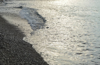 闪亮的银水海卵石海滩早期早....日出