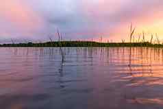 反映了光滑的水湖云日落色彩斑斓的景观背景模糊