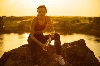 女人休息喝水运行户外锻炼热夏天日落体育运动健康的活跃的生命系统