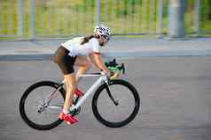 年轻的女人骑路自行车免费的街城市日落健康的生活方式体育运动概念
