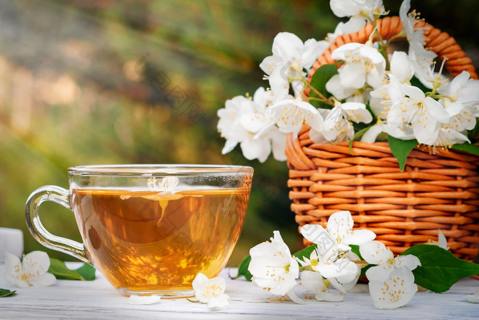 篮子花山梅花被称为茉莉花模拟橙色杯香茉莉花茶白色木托盘在户外夏天Copyspace