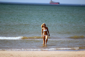 晒黑金发女郎白色比基尼太阳镜水沙子海滩游泳波罗的海海