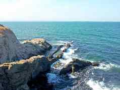 视图岩石海岸冲浪支安打岩石夏天阳光明媚的一天