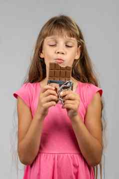 八岁的女孩快乐吃巧克力酒吧